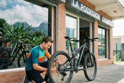 Jeune homme souriant avec vélo en extérieur à La Possession