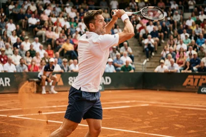 Joueur de tennis professionnel en plein service sur un court en terre battue lors d'un tournoi ATP